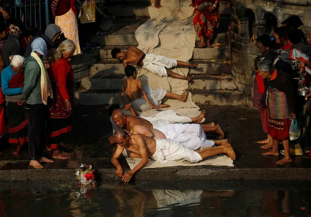 Devotees offer prayers by rolling on the ground during the Swasthani Brata Katha festival in Bhaktapur, Nepal on January 21, 2019. (Photo by Navesh Chitrakar/Reuters)