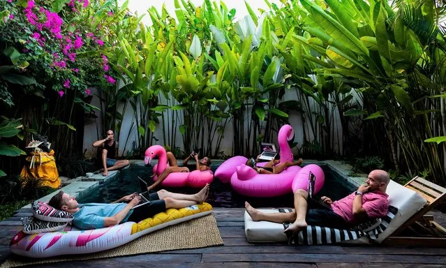 “Telework: Connected Work for Disconnected People”. Nina 31, lounging on the inflatable flamingo, conducting a work session with friends in a house in Bali. (Photo by Jerome Gence/Visa pour l'Image)