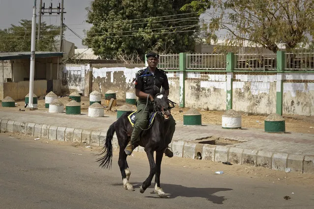 A mounted policeman rides his horse as he patrols outside the electoral commission offices in Kano, northern Nigeria Monday, February 25, 2019. (Photo by Ben Curtis/AP Photo)