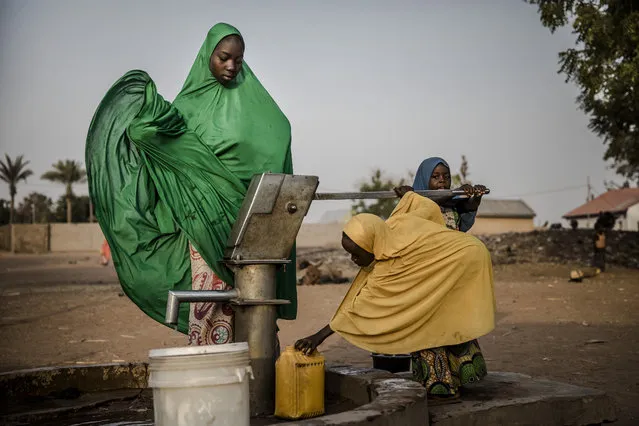 Camp dwellers pump water from a well at Malkohi refugee camp in Jimeta, Adamawa State, Nigeria on February 19, 2019, four days ahead of the country's General elections set for February 23 after a last-minute rescheduling. Malkohi is a camp for internal displaced who fled their homes as Boko Haram insurgents advanced across north-eastern Nigeria. From their homes on the outskirts of Yola, capital of presidential candidate Atiku Abubakar's home state Adamawa, Malkohi residents say they feel forgotten. (Photo by Luis Tato/AFP Photo)