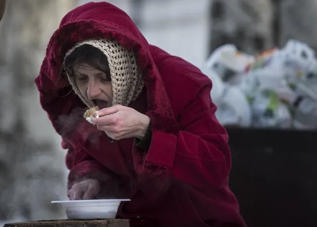 A local resident eats free food at a humanitarian aid center in Avdiivka, eastern Ukraine, Wednesday, February 1, 2017. Freezing residents of an eastern Ukraine town battered by an upsurge in fighting between government troops and Russia-backed rebels flocked to a humanitarian aid center Wednesday to receive food and warm up. (Photo by Evgeniy Maloletka/AP Photo)