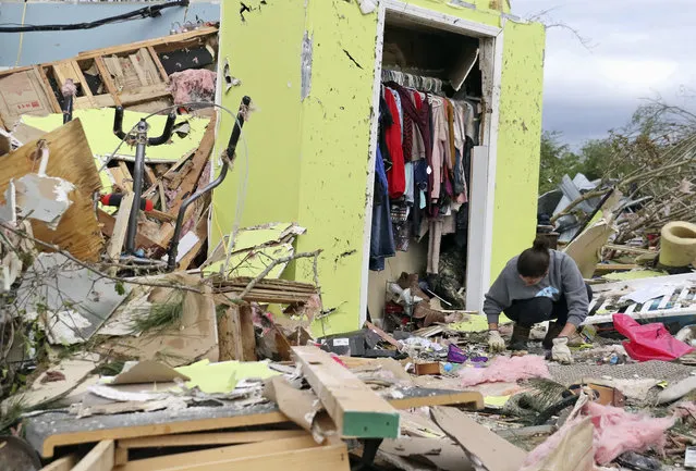Leslie Harrington kneels down to help a former neighbor and family friend look for jewelry in her destroyed home along Seely Drive outside of Hamilton, Miss., after a deadly storm moved through the area on Sunday, April 14, 2019. (Photo by Jim Lytle/AP Photo)