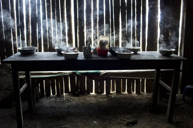 This March 15, 2015 photo shows steaming bowls of chicken soup on a table set for a special meal marking the second death anniversary of cocaine backpacker Yuri Galvez, in La Mar, province of Ayacucho, Peru. Galvez, 25, was found dead two years earlier after a smuggling trip with other backpackers. (Photo by Rodrigo Abd/AP Photo)