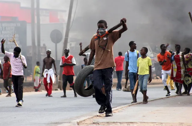 A protester carries a tyre to be used to erect a barricade as they demonstrate against the ruling CNDD-FDD party's decision to allow Burundian President Pierre Nkurunziza to run for a third five-year term in office, in Bujumbura, May 7, 2015. (Photo by Jean Pierre Aime Harerimana/Reuters)
