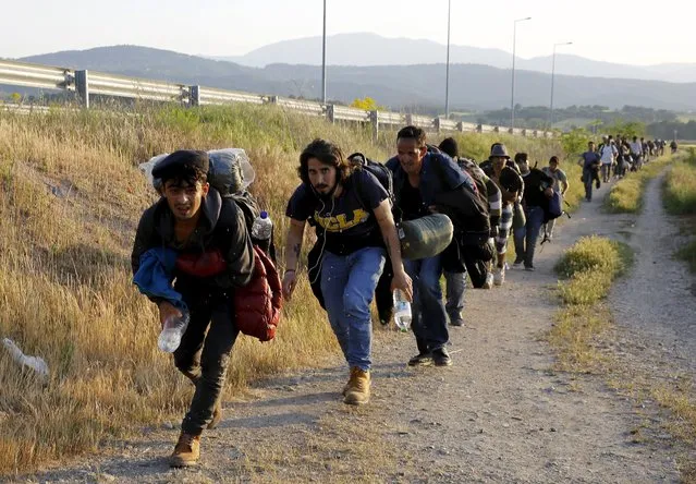 A group of Syrian immigrants run to hide from patrolling Greek police before crossing the border into Macedonia, along with another 45 Syrian immigrants, near the Greek village of Idomeni in Kilkis prefecture May 14, 2015. (Photo by Yannis Behrakis/Reuters)