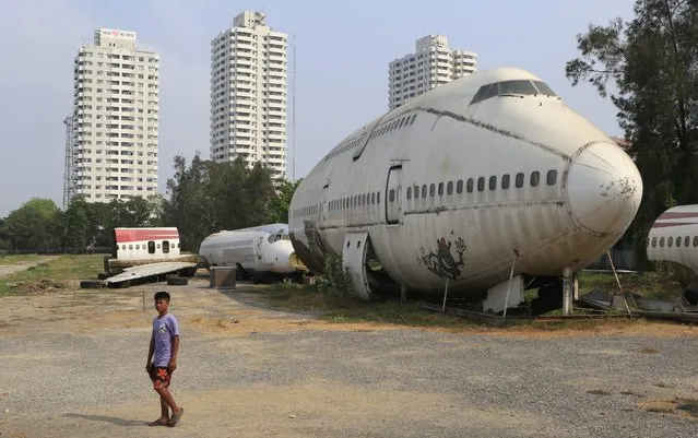 The front part of a Boeing 747 plane is seen on a block of land with other parts of dismantled aircraft near apartment buildings in Bangkok, Thailand, 20 March 2014. The planes were reportedly once a feature in a beer garden but now remain on an empty block. The mystery of where the missing Malaysia Airlines flight MH370 plane now missing for 13 days took a new turn as objects possibly related to the missing Malaysia Airlines plane have been spotted in the southern Indian Ocean, Australian officials said 20 March. (Photo by Barbara Walton/EPA)