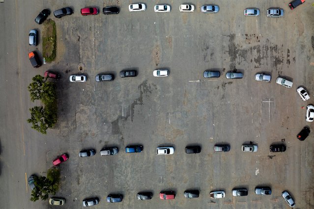 An aerial view of people queuing for a drive-in coronavirus disease (COVID-19) testing site, as the latest Omicron variant emerges as a threat, at Hiram Bithorn Stadium's parking lot in San Juan, Puerto Rico on December 23, 2021. (Photo by Ricardo Arduengo/Reuters)