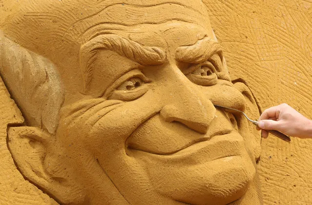 A sand carver works on a sculpture depicting French actor Louis de Funes, during the Sand Sculpture Festival “Dreams” in Ostend, Belgium on June 18, 2019. (Photo by Yves Herman/Reuters)