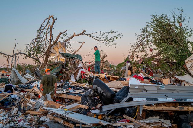The Crowder family surveys their home destroyed by a tornado on May 07, 2024 in Barnsdall, northeast Oklahoma. The EF3 twister that struck claimed one life and destroyed dozens of homes in the community of just over 1,000 people. (Photo by Brandon Bell/Getty Images/AFP Photo)