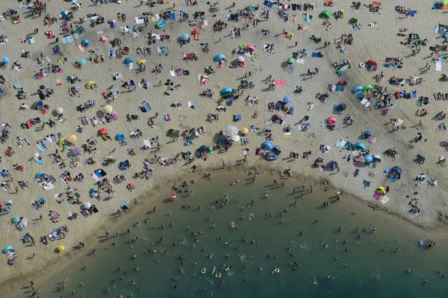 People cool off at a lake in Haltern am See, western Germany on June 26, 2019 as temperatures topped 38 degrees Celsius. Europeans are baking in what forecasters are warning will likely be record-breaking temperatures for June with the mercury set to hit 40 degrees Celsius (104 degrees Fahrenheit) as summer kicks in on the back of a wave of hot air from North Africa. (Photo by Ina Fassbender/AFP Photo)