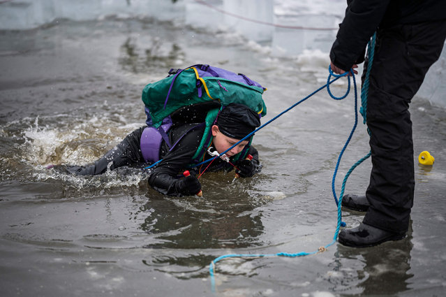 A 5th grade student from Vaxmora School in Sollentuna participates in an exercise teaching them how to react when falling into hole in the ice, on February 7, 2023, In Sollentuna, north of Stockholm. Forty pupils are taking part in an “isvaksovning” (“hole-in-the-ice exercise”), part of their school's physical education class to learn what to do if they ever fall through the ice on one of Sweden's many lakes or out in the archipelago. (Photo by Jonathan Nackstrand/AFP Photo)