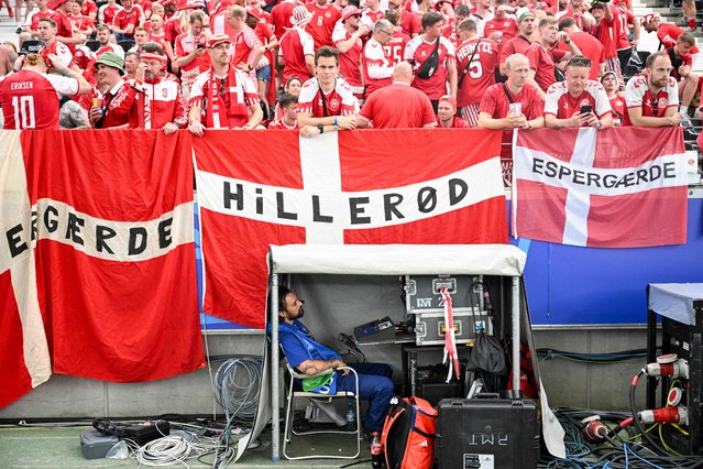 A television technician waits below Denmark's fans prior to the UEFA Euro 2024 Group C football match between Denmark and England at the Frankfurt Arena in Frankfurt am Main on June 20, 2024. (Photo by Kirill Kudryavtsev/AFP Photo)