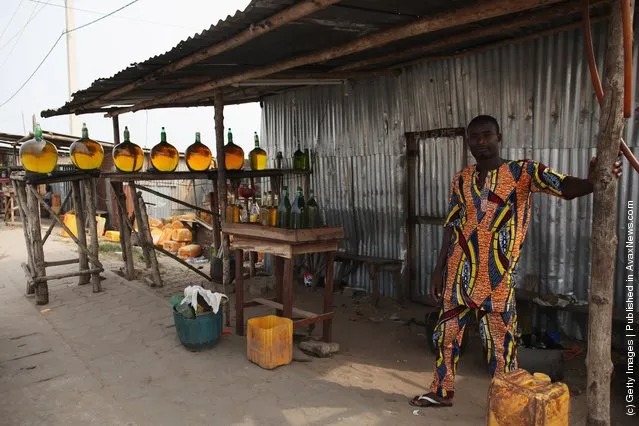 A vendor sells fuel, known locally as 'Kpayo', at the side of the road in Cotonou, Benin