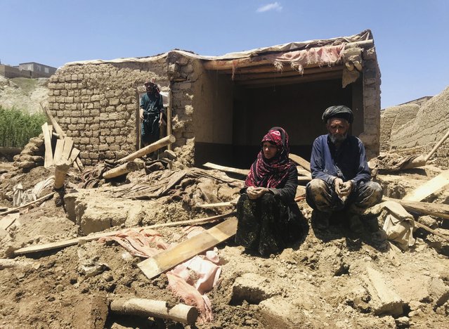 An Afghan couple sit near to their damaged home after heavy flooding in Ghor province in western Afghanistan Saturday, May 18, 2024. Flash floods from heavy seasonal rains in Ghor province in western Afghanistan killed dozens of people and dozens remain missing, a Taliban official said on Saturday, adding the death toll was based on preliminary reports and might rise. (Photo by Omid Haqjoo/AP Photo)