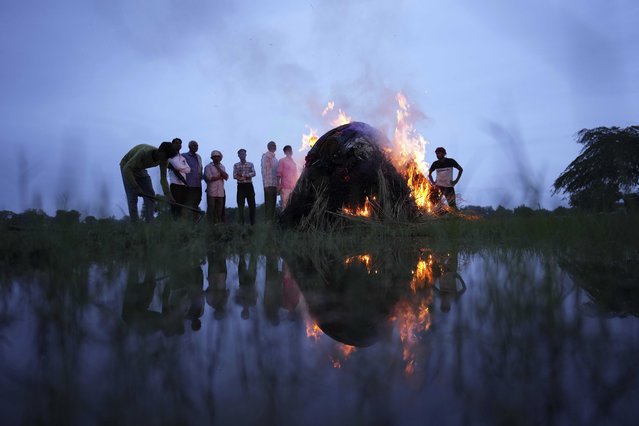 Flames rise from the cremation pyre of Savitri Devi, 50, who died during a stampede, in Ramnagar, in the northern Indian state of Uttar Pradesh, Wednesday, July 3, 2024. (Photo by Rajesh Kumar Singh/AP Photo)