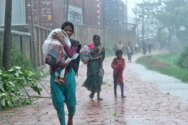 People walk in the streets in the rain as they look for shelter during the cyclone Roanu in Chittagong, Bangladesh, 21 May 2016. At least 20 people are reported killed and more than100 injured in Chittagong, Bhola, Cox’s Bazar, Noakhali and Patuakhali districts during the cyclone. (Photo by EPA/Stringer)