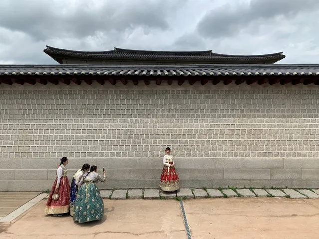 Tourists dressed in traditional Korean costumes take pictures during the visit to Gyeongbokgung Palace in Seoul, South Korea on July 29, 2019. (Photo by Antonio Bronic/Reuters)