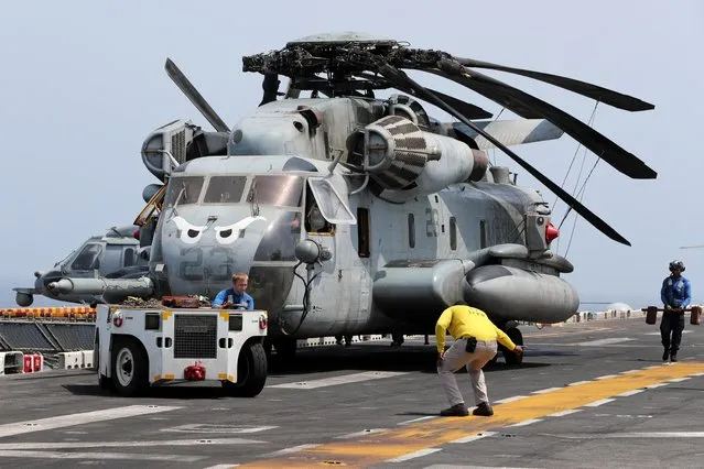 U.S. sailors move a CH-53E Super Stallion aircraft on the flight deck of USS Boxer (LHD-4) in the Arabian Sea off Oman on July 16, 2019. (Photo by Ahmed Jadallah/Reuters)