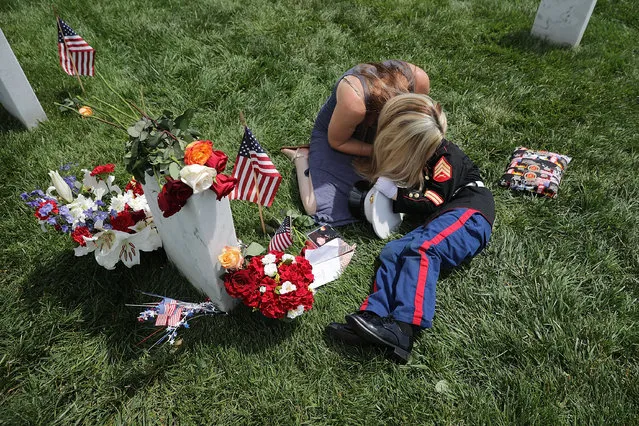 Brittany Jacobs of Hertford, North Carolina, embraces her son, Christian Jacobs, 6, while sitting next to the grave of her husband, U.S. Marine Corps Sgt. Chris Jacobs, in Section 60 at Arlington National Cemetery on Memorial Day May 29, 2017 in Arlington, Virginia. Part of the 3rd Assault Amphibian Battalion, 1st Marine Division, Sgt. Jacobs served in Aghanistan and Iraq and was killed during a training exercise in California in 2011. (Photo by Chip Somodevilla/Getty Images)