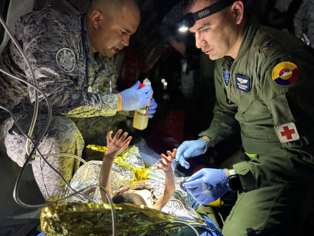 This handout picture taken on June 9, 2023 released by the Colombian Air Force shows members of the Colombian Army checking one of the four Indigenous children who were found alive after being lost for 40 days in the Colombian Amazon rainforest following a plane crash in San Jose del Guaviare during their transfer to Bogota. Exhausted but happy, four Indigenous children who had been missing for more than a month in the Colombian Amazon rainforest were reunited with their relatives Saturday, in a happy ending to a nerve-racking saga that gripped the nation. (Photo by Colombian Air Force/Handout via AFP Photo)