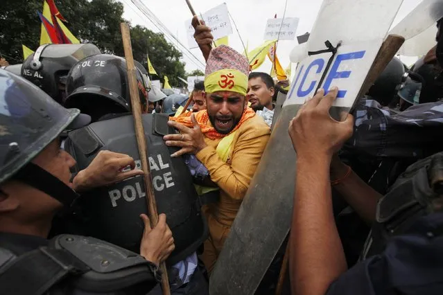Nepalese police stop Hindu activists as they try to enter a restricted area near the Nepalese Constituent Assembly Hall during a protest in Kathmandu, Nepal, Wednesday, August 5, 2015. About 500 protesters demanding Nepal be declared a Hindu state in the new constitution clashed with police. No one was injured in scuffles and there were no arrests. (Photo by Niranjan Shrestha/AP Photo)