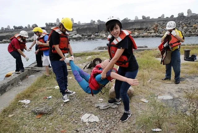 Employees of commercial ships and fishing vessels “rescue” a dummy during an emergency rescue drill as Typhoon Soudelor approaches in Keelung, northeastern Taiwan, Friday, August 7, 2015. Soudelor is expected to bring heavy rains and strong winds to the island late Friday with winds speeds over 170 km per hour (100 mph) and gusts over 200 km per hour (120 mph) according to Taiwan's Central Weather Bureau. (Photo by Wally Santana/AP Photo)