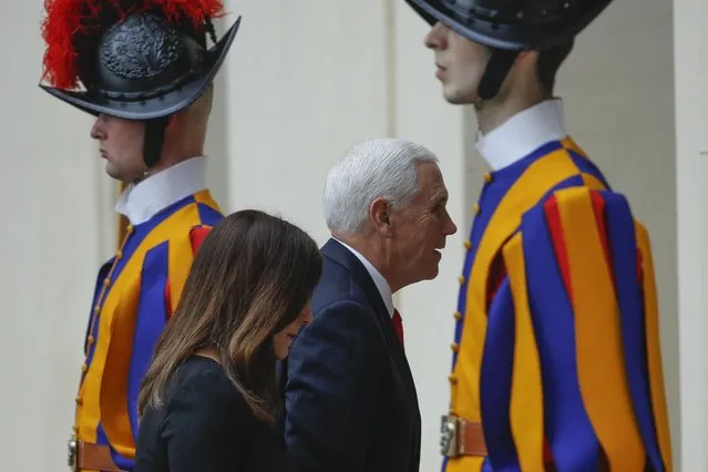 US Vice President Mike Pence and his wife Karen walk past Vatican Swiss Guards as they arrive at the San Damaso courtyard at the Vatican ahead of their private audience with Pope Francis, Friday, January 24, 2020. (Photo by Domenico Stinellis/AP Photo)