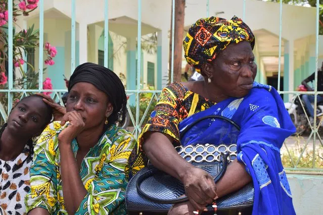Relatives sit outside the Abdoul Aziz Sy Dabakh Hospital in Tivaouane, Senegal, a town 90 kms ( 60 miles) east of Dakar Thursday, May 26, 2022. Senegal's president says 11 newborns have died in a fire that broke out in the neonatal unit of a hospital. Authorities in the town of Tivaouane said only three babies could be saved after a short circuit caused the blaze. (Photo by Cheik Sy/AP Photo)