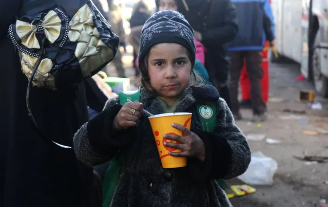 A Syrian girl, who was evacuated from the last rebel-held pockets of Syria's northen city of Aleppo, eats upon arriving on December 20, 2016 in the opposition-controlled Khan al-Assal region, west of the embattled city. At least 25,000 people have left the bombed-out eastern districts of Syria's Aleppo since evacuations began last week, the International Committee of the Red Cross said. (Photo by Baraa Al-Halabi/AFP Photo)