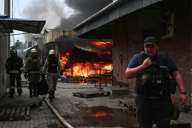 Firefighters work to control flames at the central market of Sloviansk on July 5, 2022, following a suspected missile attack amid the Russian invasion of Ukraine. (Photo by Miguel Medina/AFP Photo)
