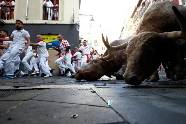 Revellers run during the running of the bulls at the San Fermin festival in Pamplona, Spain on July 7, 2022. (Photo by Juan Medina/Reuters)