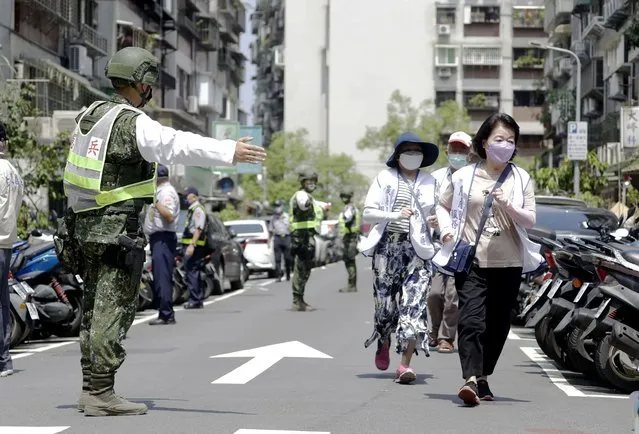 People are guided by Taiwan's soldiers to a basement shelter during the Wanan air raid drill in Taipei, Taiwan, Monday, July 25, 2022. Taiwan’s capital staged air raid drills Monday and its military mobilized for routine defense exercises, coinciding with concerns over a forceful Chinese response to a possible visit to the island by U.S. Speaker of the House Nancy Pelosi. (Photo by Chiang Ying-ying/AP Photo)
