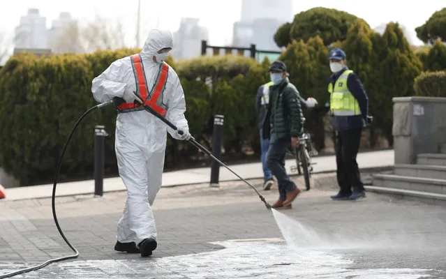 A soldier wears protective gear as he disinfects as a precaution against the new coronavirus in Seoul, South Korea, Thursday, March 12, 2020. For most people, the new coronavirus causes only mild or moderate symptoms, such as fever and cough. For some, especially older adults and people with existing health problems, it can cause more severe illness, including pneumonia. (Photo by Lee Jin-man/AP Photo)
