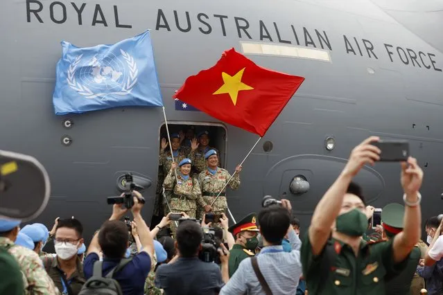 Vietnamese forces taking part in the United Nations peacekeeping mission in South Sudan wave flags in front of a Royal Australian Air Force aircraft during a departure ceremony, in Hanoi, Vietnam, 27 April 2022. (Photo by Luong Thai Linh/EPA/EFE)