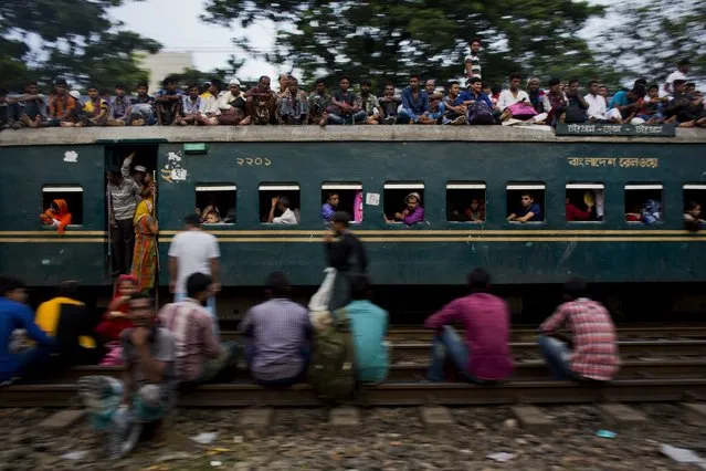 Bangladeshi Muslims travel on the roof of an overcrowded train as they head to their hometowns ahead of Eid al-Adha in Dhaka, Bangladesh, Friday, September 1, 2017. The festival commemorates the story of Abraham and his readiness to sacrifice his son as an act of obedience to God, who provided a lamb to be used instead. (Photo by Bernat Armangue/AP Photo)