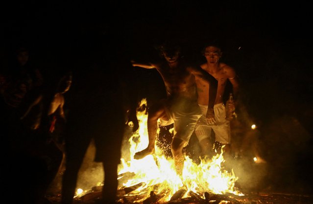 Followers of the goddess Maria Lionza run through burning embers during a spiritual ritual that combines Indigenous, Catholic and African beliefs, in Quibayo, Venezuela on October 12, 2024. (Photo by Juan Carlos Hernandez/Reuters)