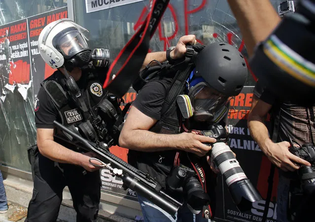 A Turkish riot policeman pushes a photographer during a protest at Taksim Square in Istanbul June 11, 2013. (Photo by Murad Sezer/Reuters)