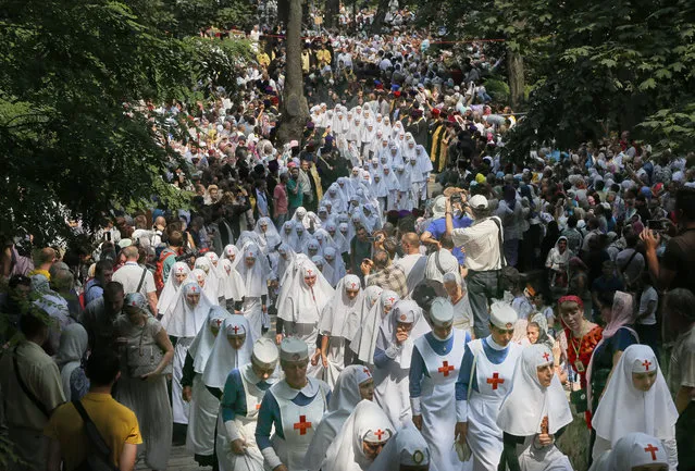 Orthodox believers and clergymen march to prayer in downtown Kiev, Ukraine, Wednesday, July 27, 2016 in observance of the holiday marking the adoption of Christianity by what is now Russia and Ukraine in the 10th century. They are to commemorate the day at the hillside monument in central Kiev to Saint Volodymyr, the prince who enacted the adoption of Christianity. (Photo by Efrem Lukatsky/AP Photo)