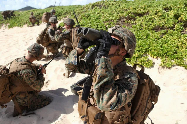 A U.S. Marine checks GPS coordinates for his mortar team during a simulated beach assault at Marine Corps Base Hawaii with the 3rd Marine Expeditionary Unit during the multi-national military exercise RIMPAC in Kaneohe, Hawaii, July 30, 2016. (Photo by Hugh Gentry/Reuters)