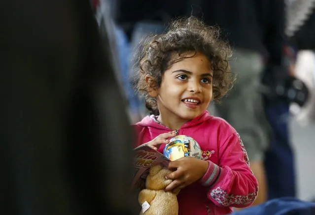 A migrant girl stands with her teddy bear at a railway station in Vienna, Austria September 5, 2015. (Photo by Dominic Ebenbichler/Reuters)