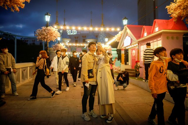 A couple removes temporarily protective face masks that they wear to avoid the spread of the coronavirus disease (COVID-19), as they take a picture at an amusement park in Seoul, South Korea on April 30, 2020. (Photo by Kim Hong-Ji/Reuters)