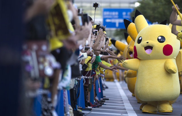 Performers dressed as Pikachu, a character from Pokemon series game titles, march during the Pikachu Outbreak event hosted by The Pokemon Co. on August 7, 2016 in Yokohama, Japan. A total of 1, 000 Pikachus appear at the city's landmarks in the Minato Mirai area aiming to attract visitors and tourists to the city. The event will be held through Aug. 14. (Photo by Tomohiro Ohsumi/Getty Images)
