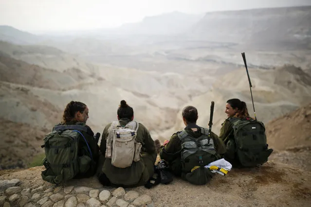 Israeli soldiers of the Caracal battalion rest after finishing a march May 29, 2014. (Photo by Amir Cohen/Reuters)