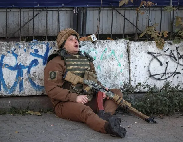 A Ukrainian serviceman takes cover as an air-raid siren sounds during a Russian drone strike, which local authorities consider to be Iranian-made unmanned aerial vehicles (UAVs) Shahed-136, amid Russia's attack on Ukraine, in Kyiv, Ukraine on October 17, 2022. (Photo by Gleb Garanich/Reuters)