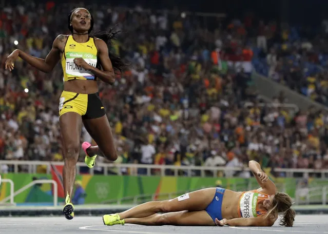 Second placed Netherlands' Dafne Schippers lies on the ground after falling over the finish line as Elaine Thompson from Jamaica, left, wins the gold in the women's 200-meter final during the athletics competitions of the 2016 Summer Olympics at the Olympic stadium in Rio de Janeiro, Brazil, Wednesday, August 17, 2016. (Photo by David J. Phillip/AP Photo)