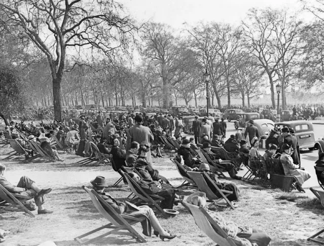 Automobiles line a roadside through Hyde Park, London, on May 4, 1941, the sunshine attracting  crowds despite the threat of air raids. This is part of the crowd that caused seat ticket-sellers to report “capacity business”. (Photo by AP Photo)