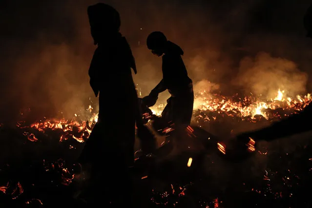 Silhouette of participants during fire war ceremony at Dalem Temple on October 8, 2014 in Tuban, Kuta, Indonesia. (Photo by Putu Sayoga/Getty Images)