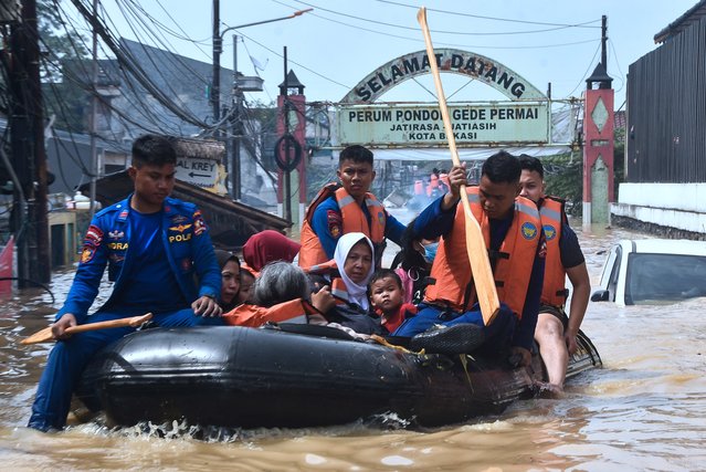 Rescue teams evacuate people whose homes have been flooded at Pondok Gede Permai Housing Complex in Bekasi, West Java on March 4, 2025. (Photo by REZAS/AFP Photo)