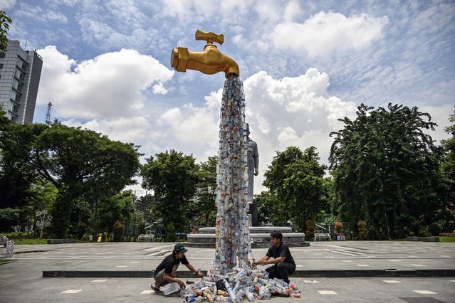 Activists from the Ecological Observation and Wetlands Conservation (ECOTON) and students put up a faucet-shaped installation that drains out plastic waste during a protest to raise awareness of the impact of single-use plastic on the environment and human health in Surabaya on February 25, 2025. (Photo by Juni Kriswanto/AFP Photo)