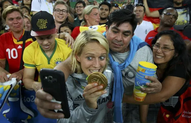 2016 Rio Olympics, Soccer, Victory Ceremony, Women's Football Tournament Victory Ceremony, Maracana, Rio de Janeiro, Brazil on August 20, 2016. Saskia Bartusiak (GER) of Germany bites her gold medal as she poses for a picture with spectators. (Photo by Murad Sezer/Reuters)